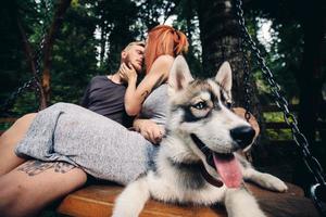 hermosa pareja junto con un perro en un columpio foto