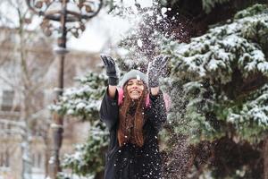 la niña arroja nieve en la ciudad. foto