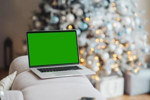 laptop with green screen - chromakey near New Year's decorations. christmas theme. photo
