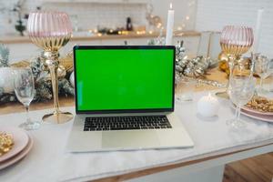 laptop with green screen - chromakey near New Year's decorations. christmas theme. photo