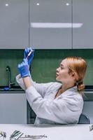 Female medical or scientific researcher looking at a test tube in a laboratory. photo