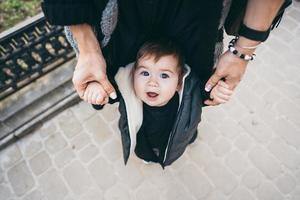 Dad holding his son by the hands photo