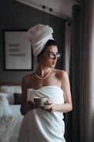 Girl wrapped in a towel drinking coffee photo