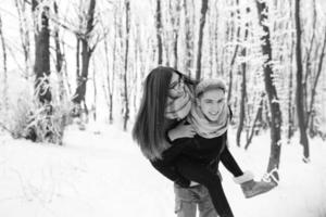 pareja feliz jugando juntos en el parque de nieve foto