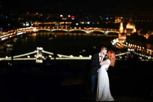 encantadora novia y novio en un fondo de budapest foto