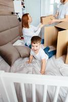 Dad mom and little son play in the bedroom with paper boxes photo