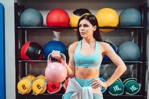 Young adult girl doing strength exercises in the gym photo