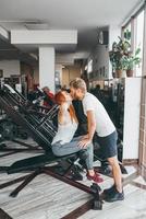 chico besa a la novia en el entrenamiento en el gimnasio foto