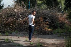 The man in the authentic boots and selvedge jeans  on a the background of branches photo