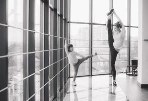 Mother learning daughter to make a high leg strech photo