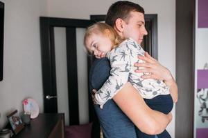 una niña con un papá en sus brazos foto