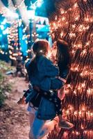 mamá besa a su hija en el parque nocturno foto