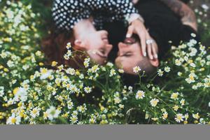 pareja joven se encuentra en el campo con margaritas. foto