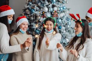 Multi-ethnic young people celebrating New year eve holding sparklers photo