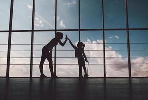 silueta de madre e hija en el gym.high five. foto