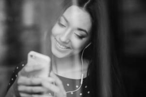 hermosa chica escuchando música en el teléfono con auriculares foto