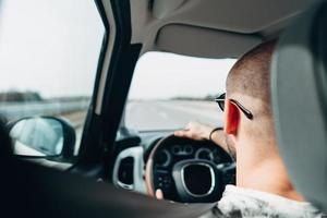 The man in the car traveling on the road photo