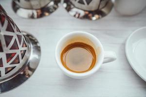 taza de capuchino en la mesa de madera blanca. foto