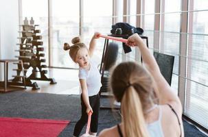 Little girl and mom doing exercises with sticks photo