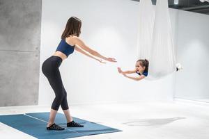 Mom and Daughter are doing yoga. Family in a gym. photo