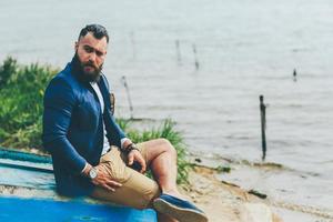 American Bearded Man looks on the river bank photo