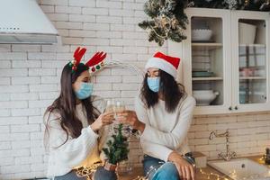 Two girls chatting, gossiping in the kitchen on new year's eve photo