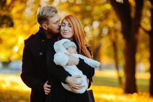 young family and newborn son in autumn park photo