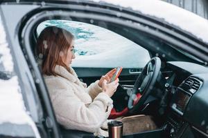 Attractive woman driver nsitting behind the steering wheel in her car photo