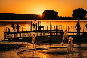 stream of a fountain splashes water, sunset photo