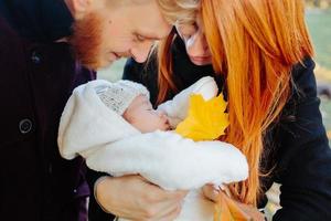 young family and newborn son in autumn park photo