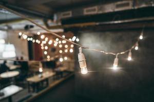 Lamp on garland with lights on background photo