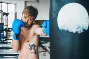 Boxer with punching bag in gym photo