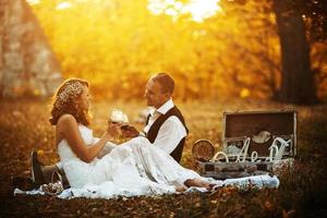 Beautiful wedding couple at a picnic under tree photo