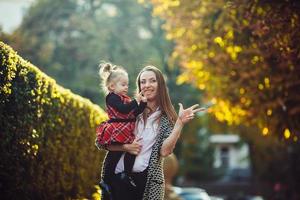 Mother and little daughter playing in a park photo