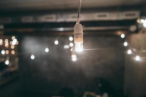 Lamp on garland with lights on background photo