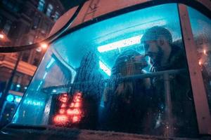 The guy and the girl kiss on the tram behind the misted glass photo