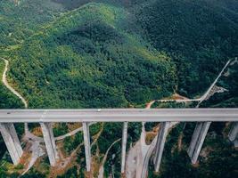 Aerial view of the road in the mountains over the bridge photo