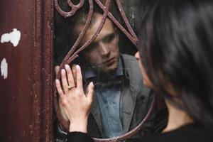 European young couple looking at each other through the window photo