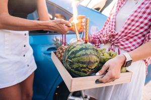 Girls hold a fruit tray and prepare a festive firework. photo