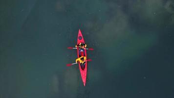 two athletic man floats on a red boat in river photo