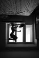 woman doing yoga asana on window sill photo