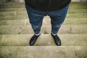 Legs of man weared in jeans on authentic stairs photo