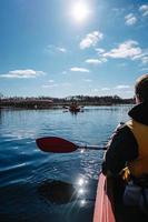 Group of people in kayaks among reeds on the autumn river. photo