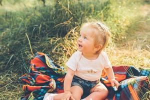 little girl sitting on the lawn photo