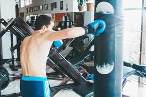 boxeador con saco de boxeo en el gimnasio foto