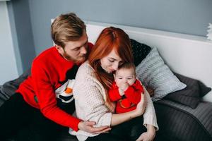 Happy family with newborn baby on the bed photo