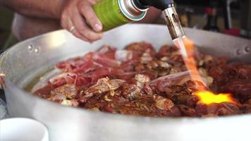 A man with a torch burns the surface of the meat photo