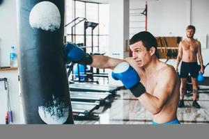 Boxer with punching bag in gym photo