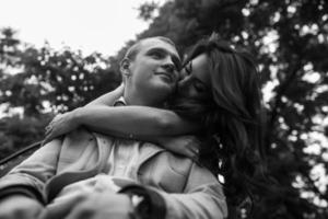 Young European couple cuddling on a park bench photo