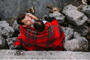 Young beautiful couple sitting on the beach photo